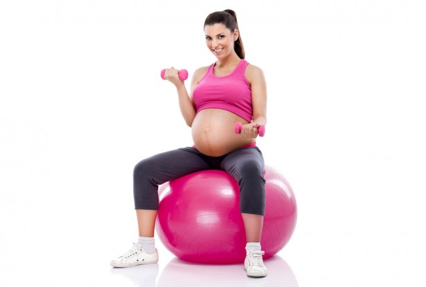 Un grupo de jóvenes madres embarazadas se dedican a pilates y deportes de  pelota en un gimnasio. embarazada